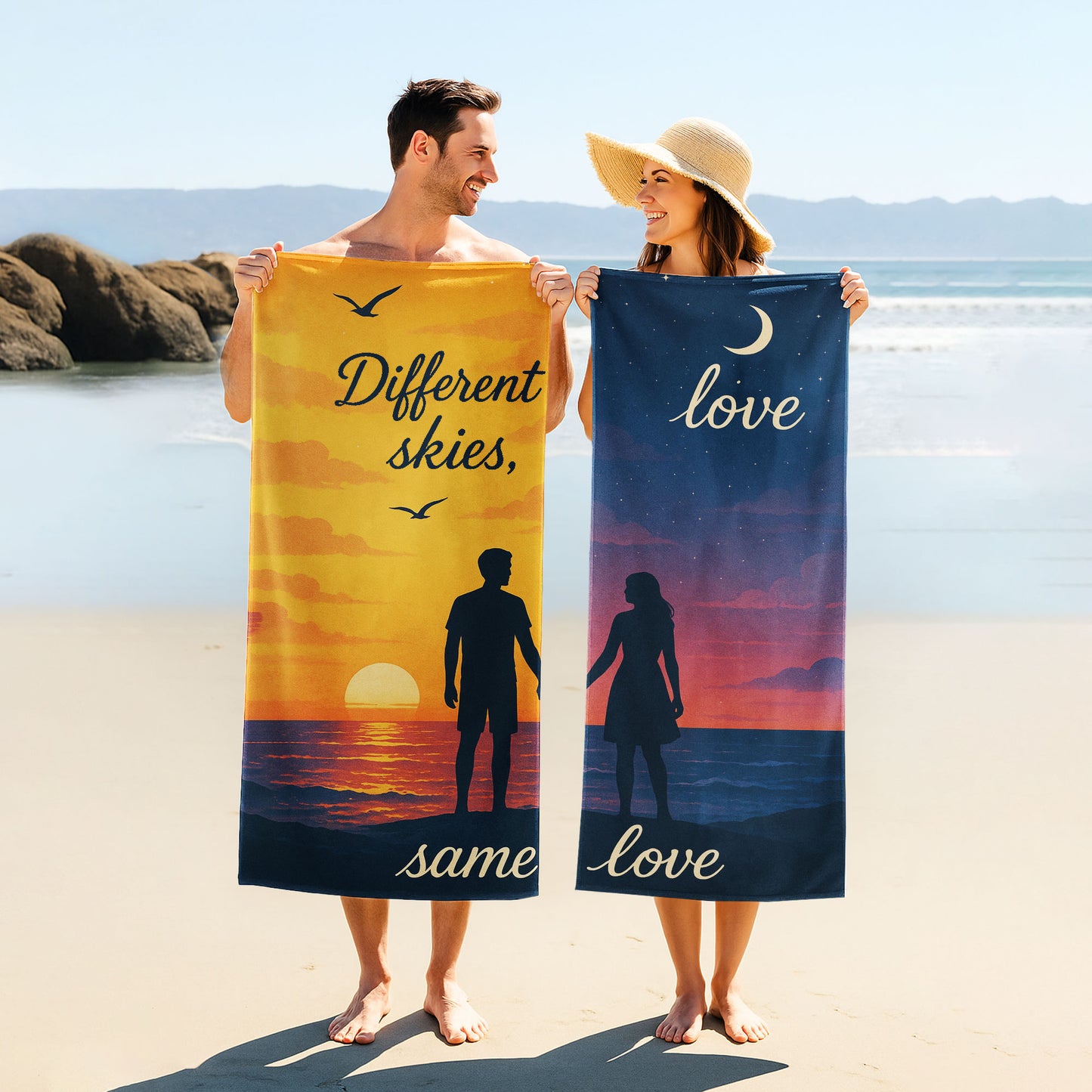 A man and a woman holding up custom beach towels on a beach. One towel shows a sunset scene with a male silhouette and text "Different skies, same love". The other shows a night sky scene with a female silhouette and text "love, same love".