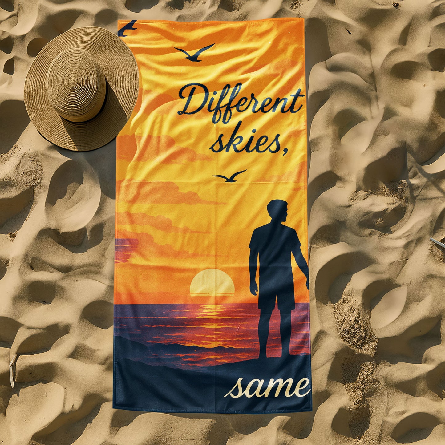 A man and a woman holding up custom beach towels on a beach. One towel shows a sunset scene with a male silhouette and text "Different skies, same love". The other shows a night sky scene with a female silhouette and text "love, same love".