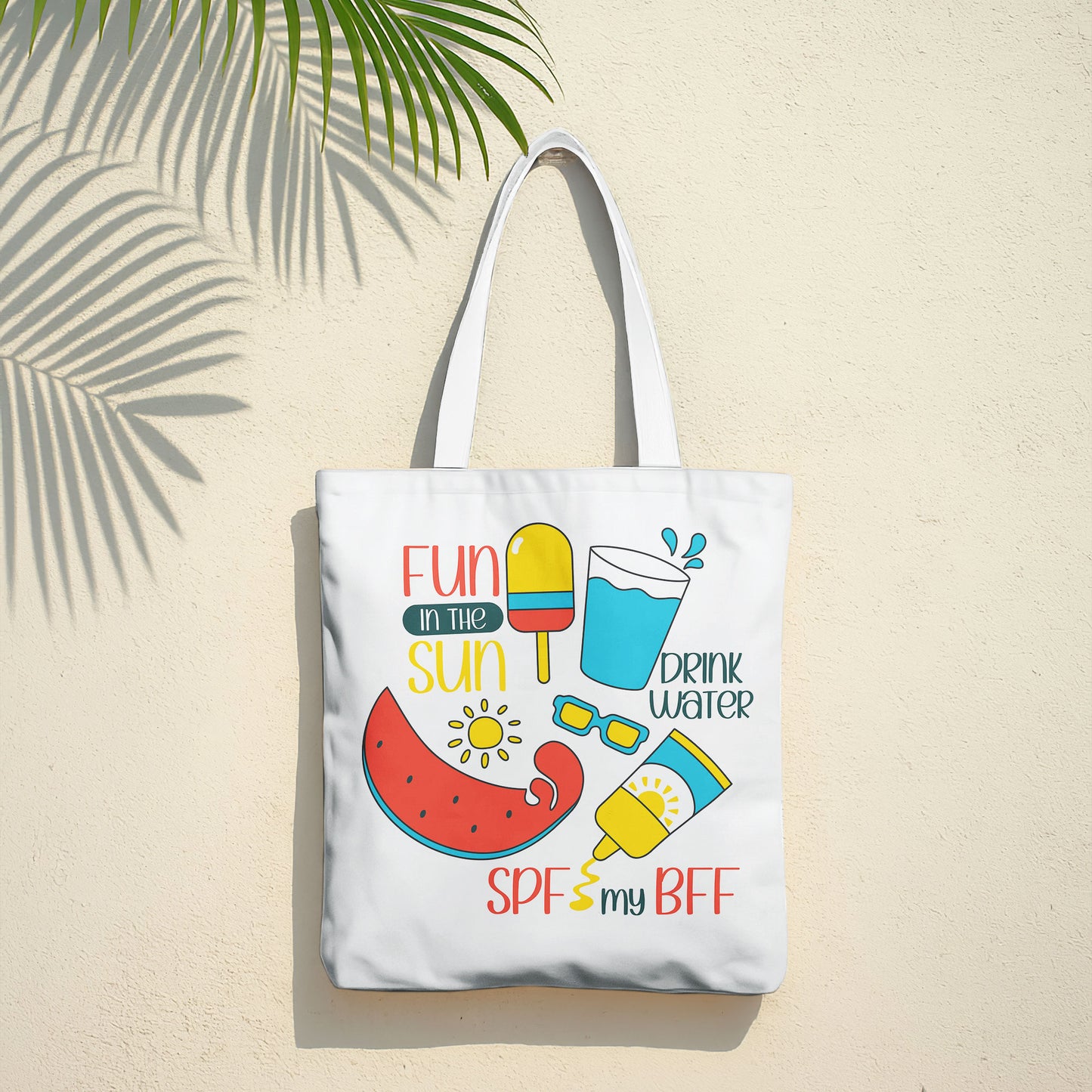 White beach tote bag with colorful 'Fun in the Sun' graphics including watermelon, popsicle, water, sunglasses, and sunscreen