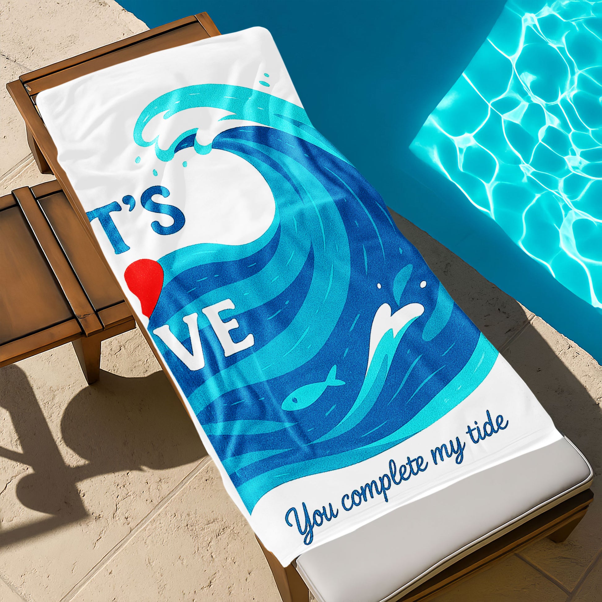 A couple holding up custom white beach towels with large blue wave designs and romantic phrases, "I'm your wave" and "You complete my tide," on a sunny beach.