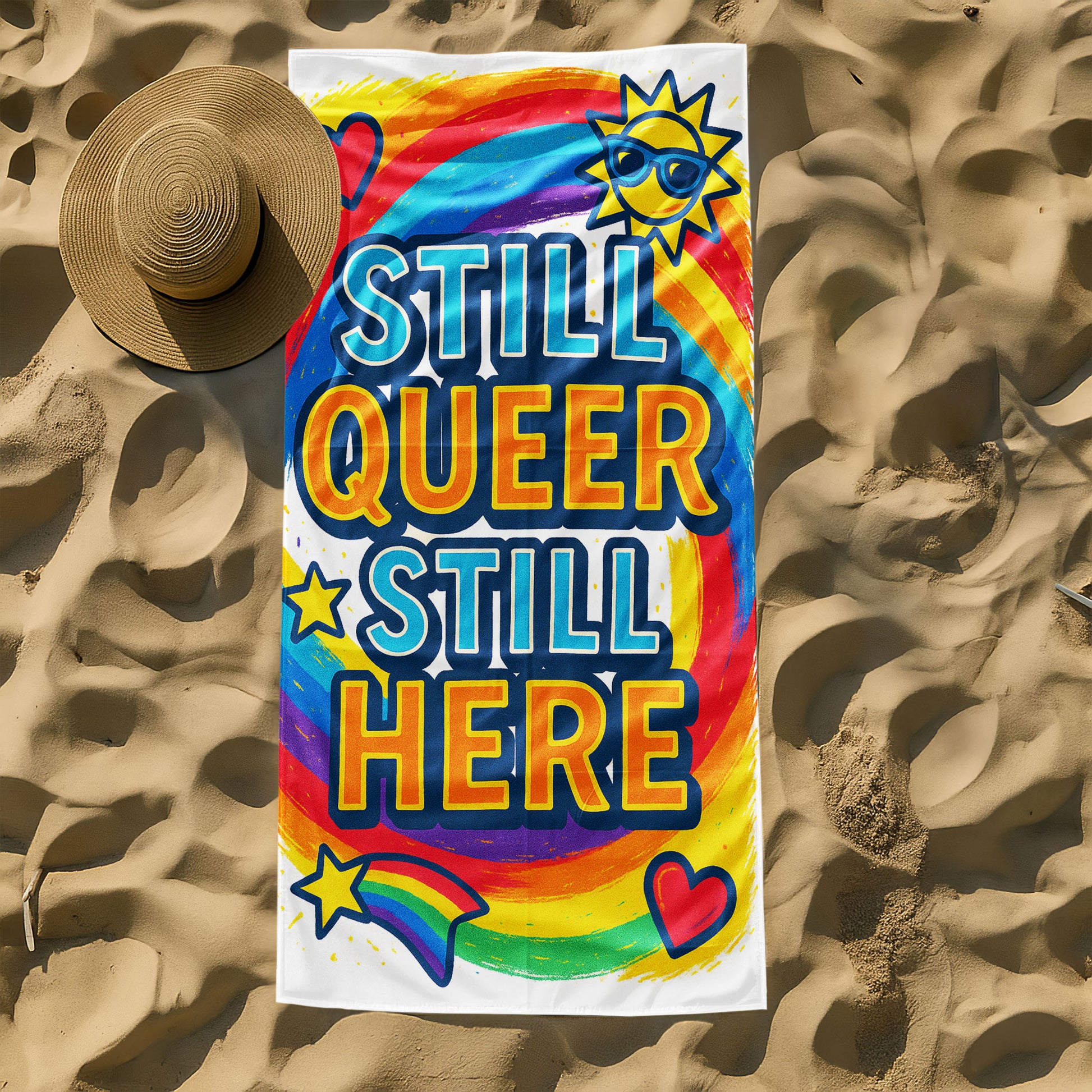 A person holding up a vibrant white beach towel with a swirling rainbow background. The towel features large, bold text "STILL QUEER STILL HERE", along with colorful icons like a sun with sunglasses, hearts, and a rainbow shooting star. The scene is a sunny beach.
