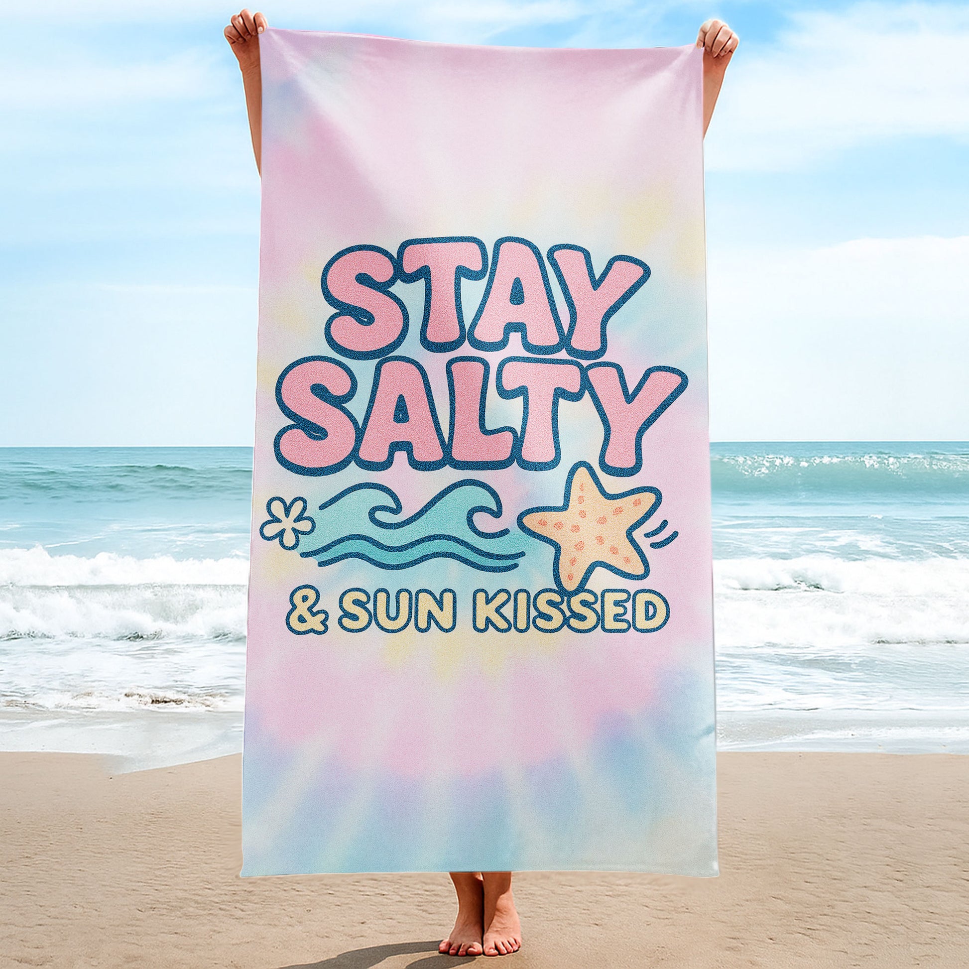 "Stay Salty & Sun Kissed" Tie-Dye Beach Towel with pastel pink, yellow, and blue background, large text "STAY SALTY & SUN KISSED", waves, and a starfish on a beach with ocean background.