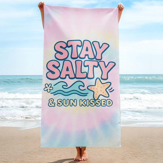 "Stay Salty & Sun Kissed" Tie-Dye Beach Towel with pastel pink, yellow, and blue background, large text "STAY SALTY & SUN KISSED", waves, and a starfish on a beach with ocean background.