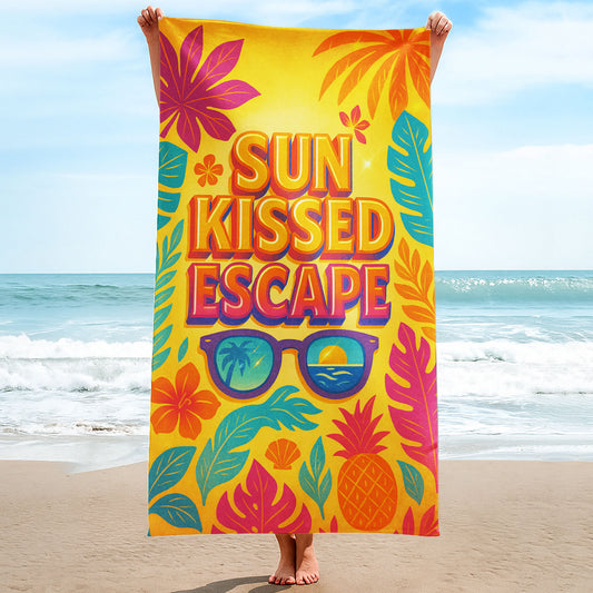 Sun Kissed Escape Beach Towel with a vibrant yellow background, tropical leaves, flowers, pineapple, sunglasses reflecting a sunset, and "SUN KISSED ESCAPE" text on a beach with ocean background.