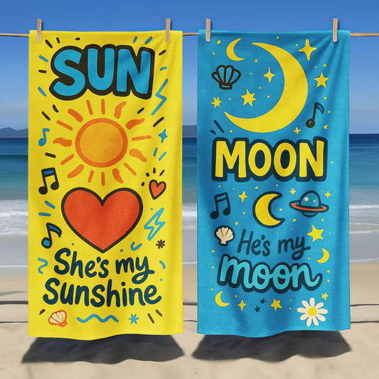Matching beach towels for couples – one yellow towel with “She’s My Sunshine” and one blue towel with “He’s My Moon” hanging by the beach.