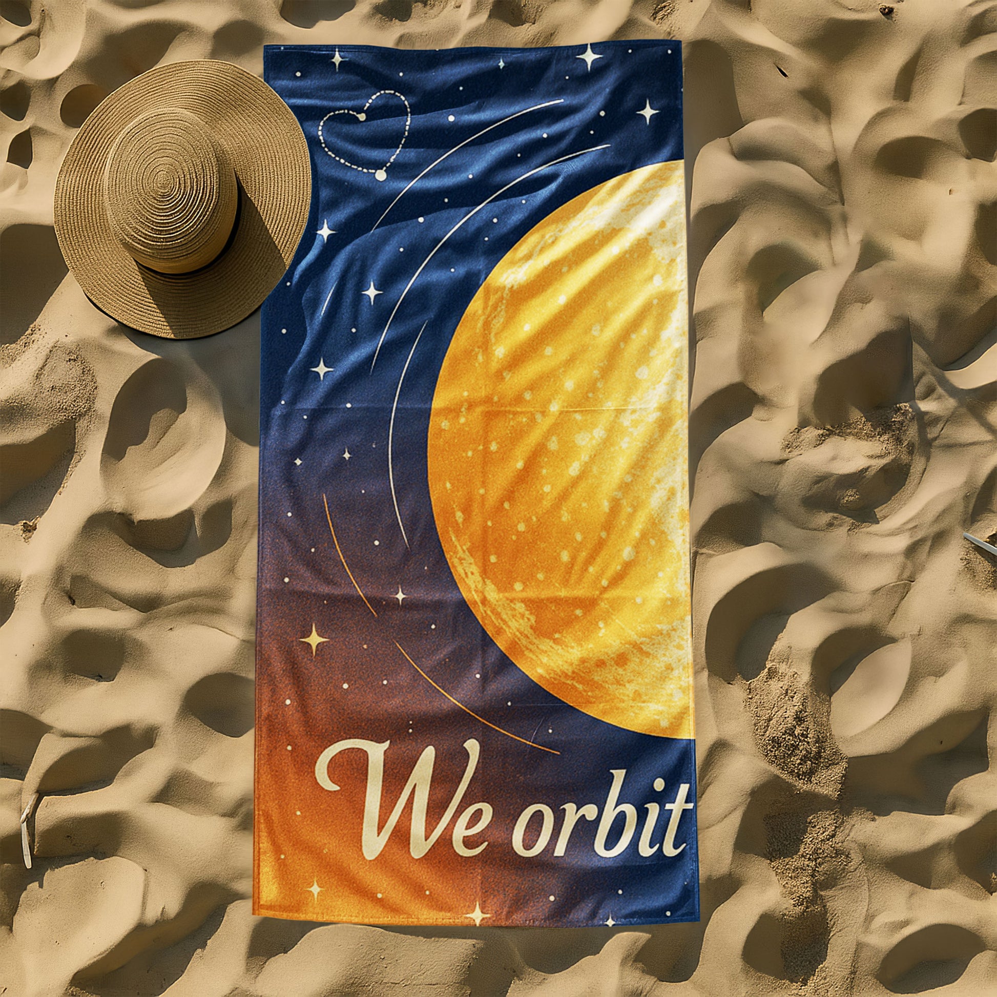  A man and a woman holding up custom beach towels on a beach. One towel shows a large golden planet with stars and "We orbit each other". The other shows a blue planet with orbits and stars, also part of "We orbit each other".
